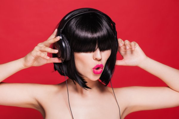girl black headphones on ears brunette red background 